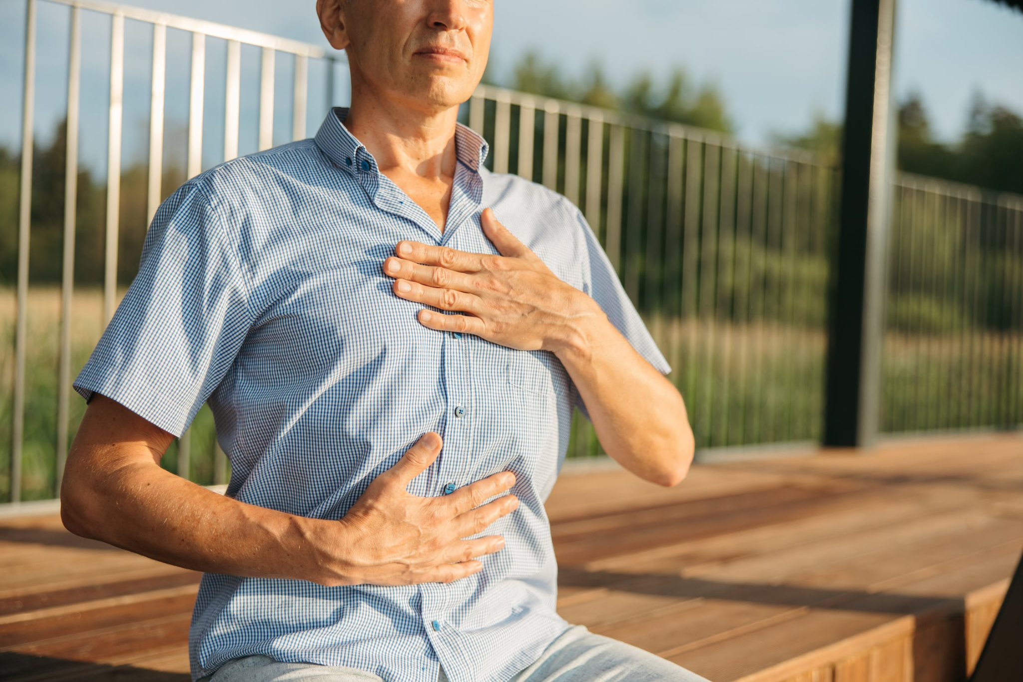 A man experiencing acid reflux in a park