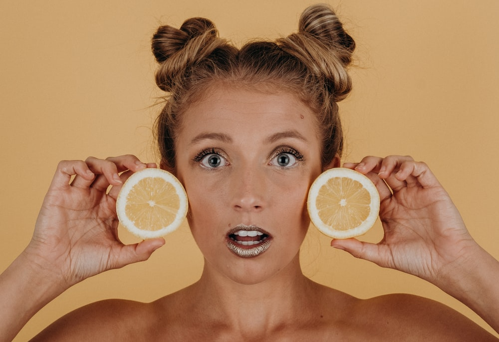 Photo of a girl using lemon on her skin