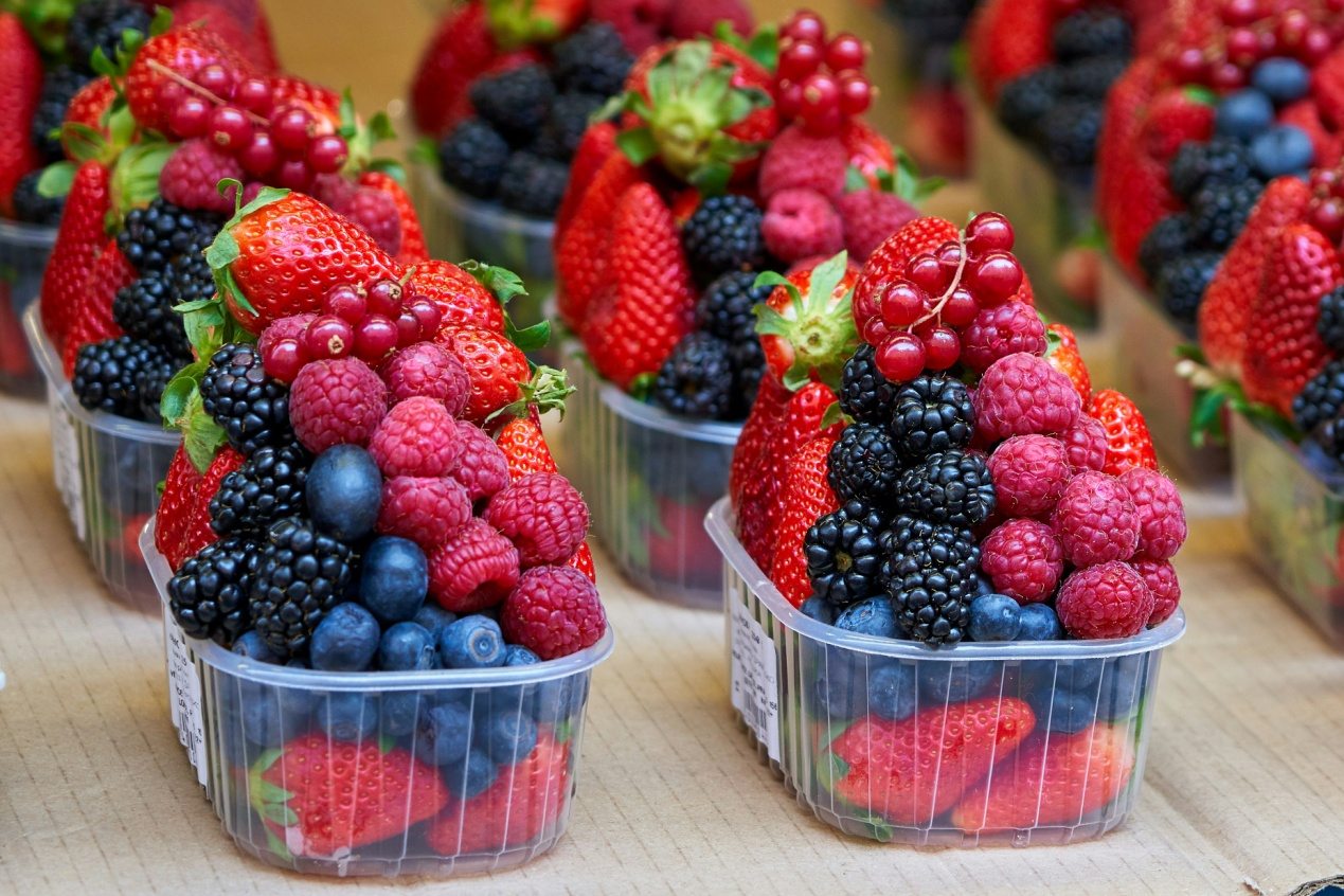 Assorted berries in disposable plastic boxes