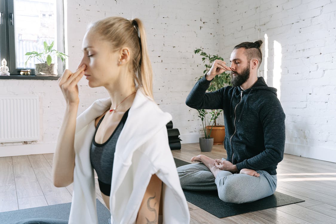 A man and a woman doing a breathing exercise