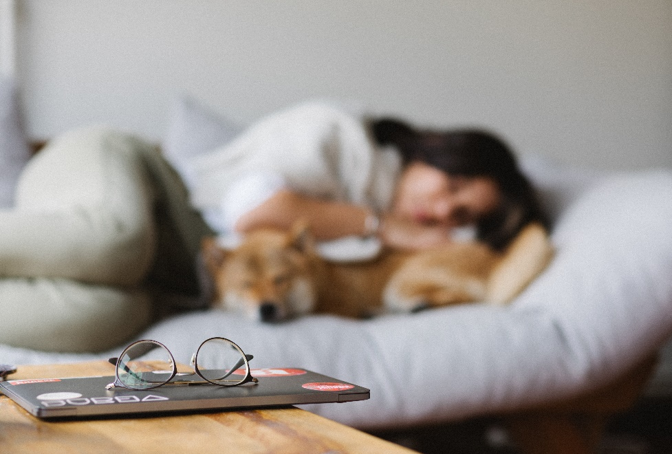 A blurred photo of a woman and a dog sleeping