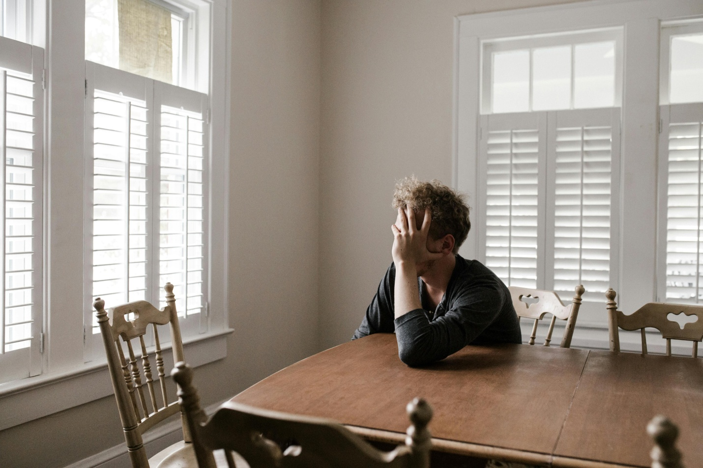 Stressed person leaning on a wooden table