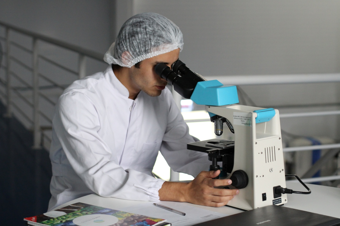 A doctor testing a cell sample under a microscope