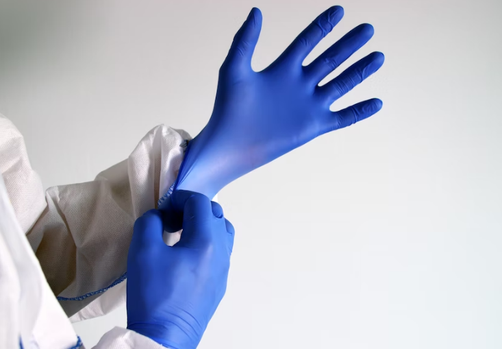 A doctor putting on gloves