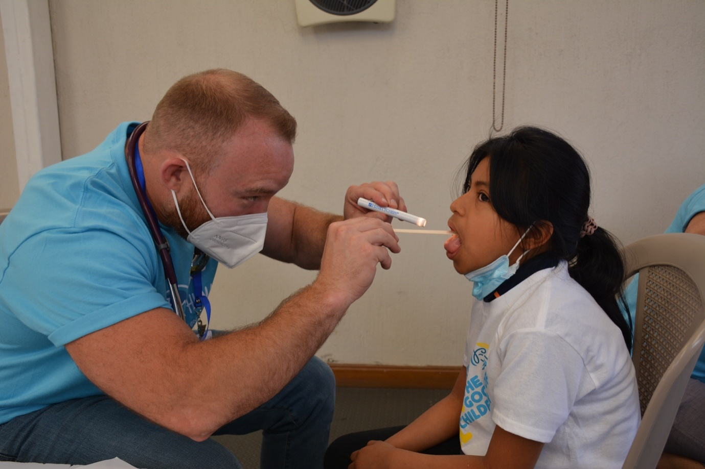 A doctor performing a throat exam on a patient