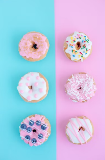 Highly decorated donuts on a pink and blue surface