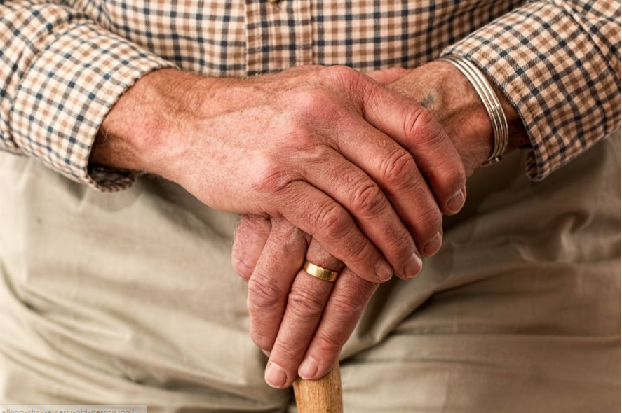 an old man leaning on a walking stick