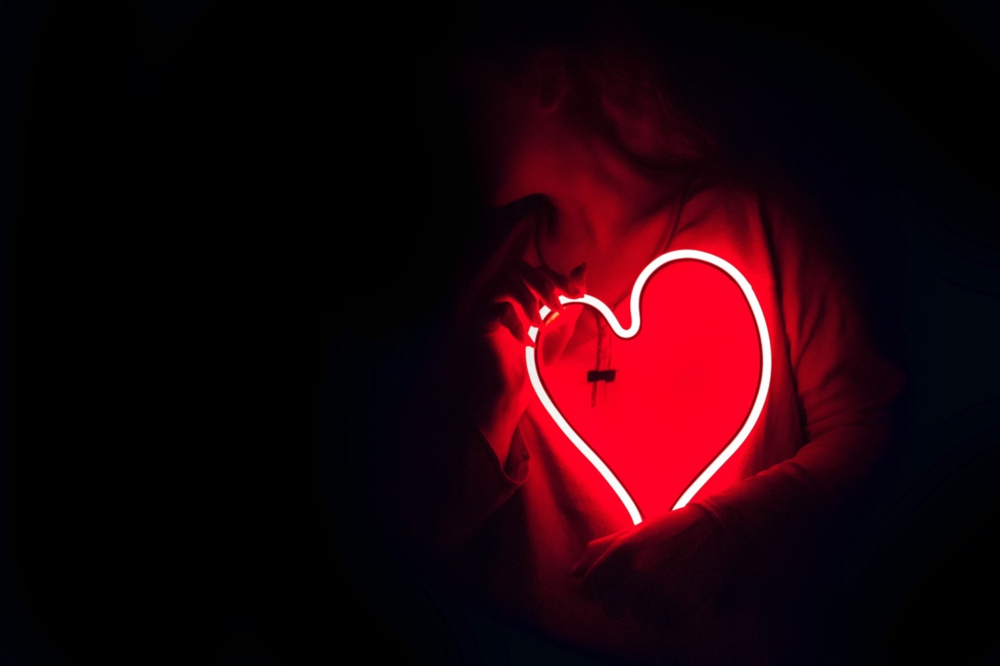 A person holding a heart-shaped light