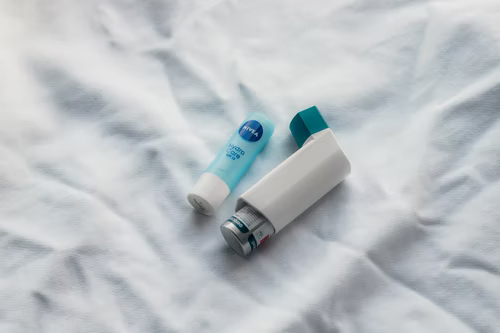  Inhaler and chapstick on a white sheet