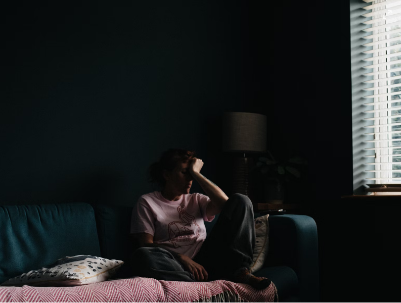 woman sitting on sofa looking depressed