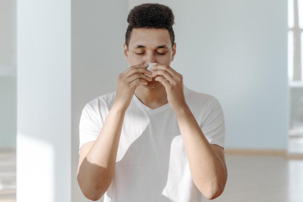 A man holding a tissue to his nose