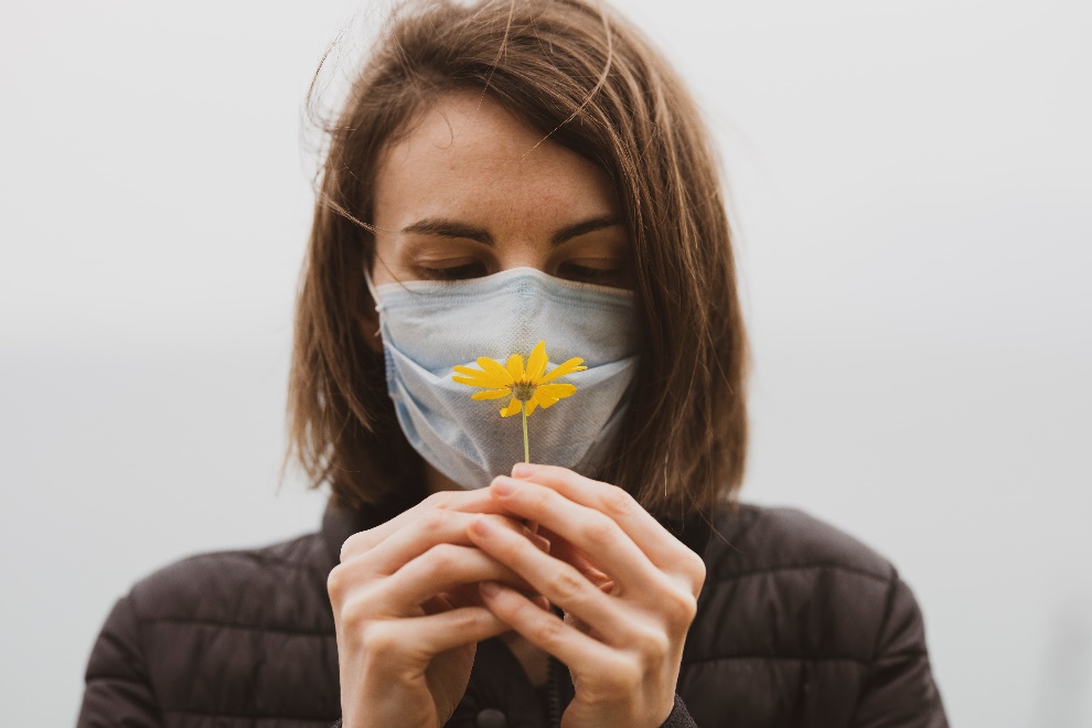 Woman with a face mask and a flower