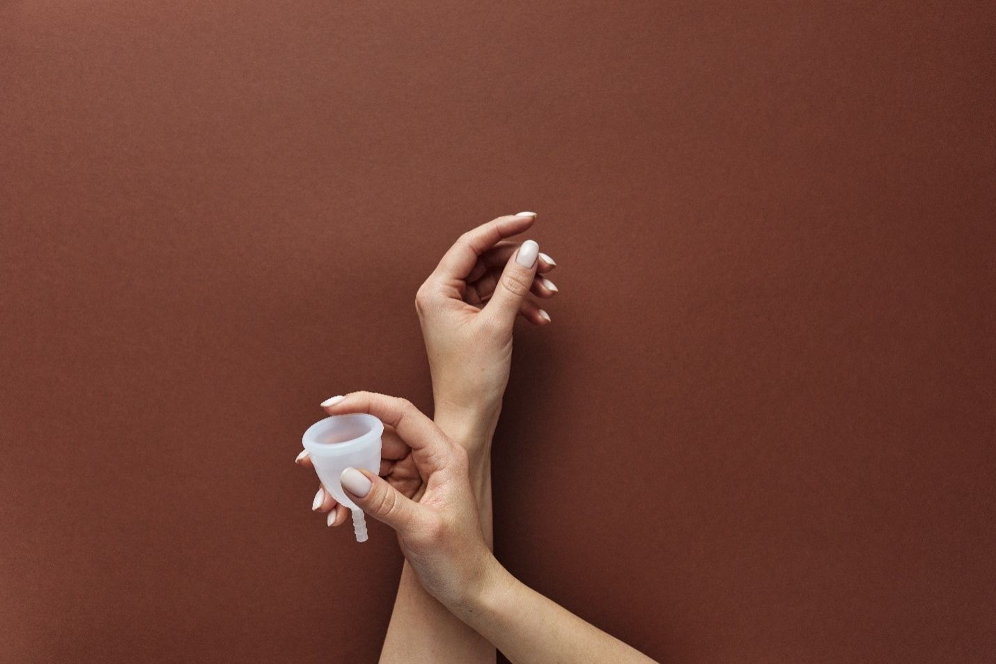 A pair of hands holding a menstrual cup