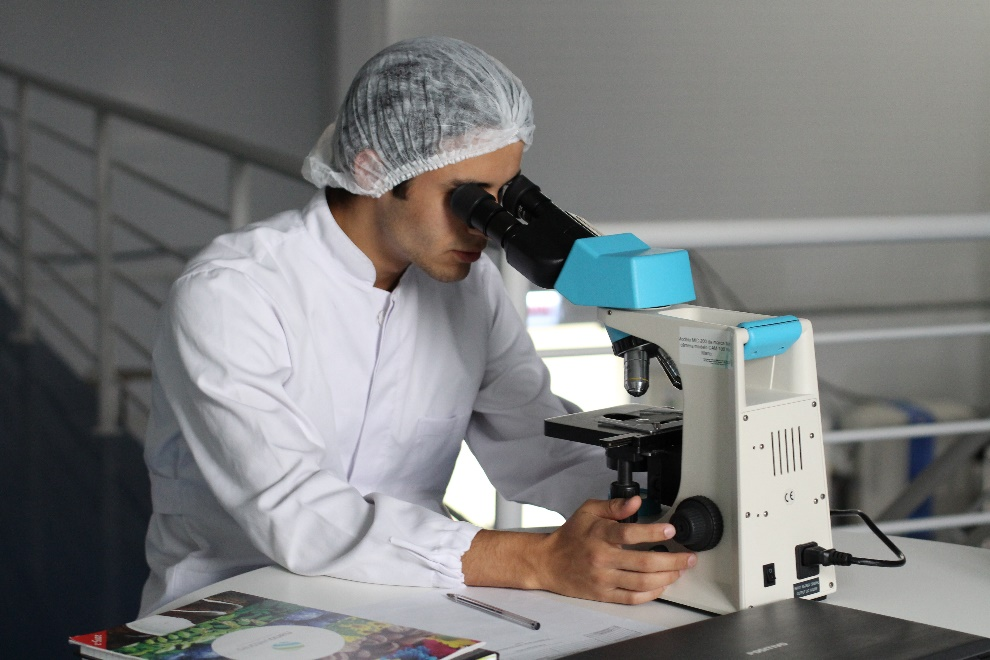 Medical expert using a microscope