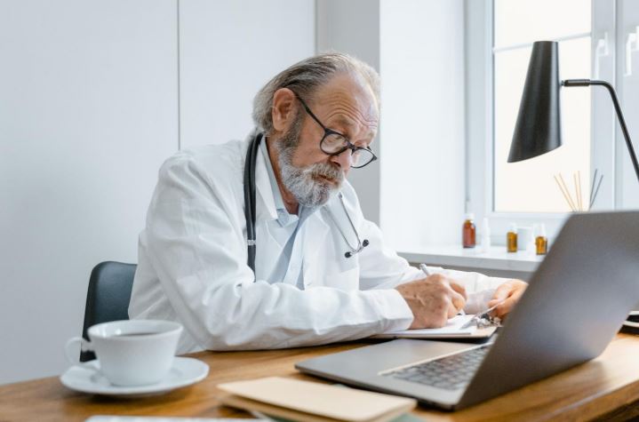 Doctor making a medical report during a consultation.