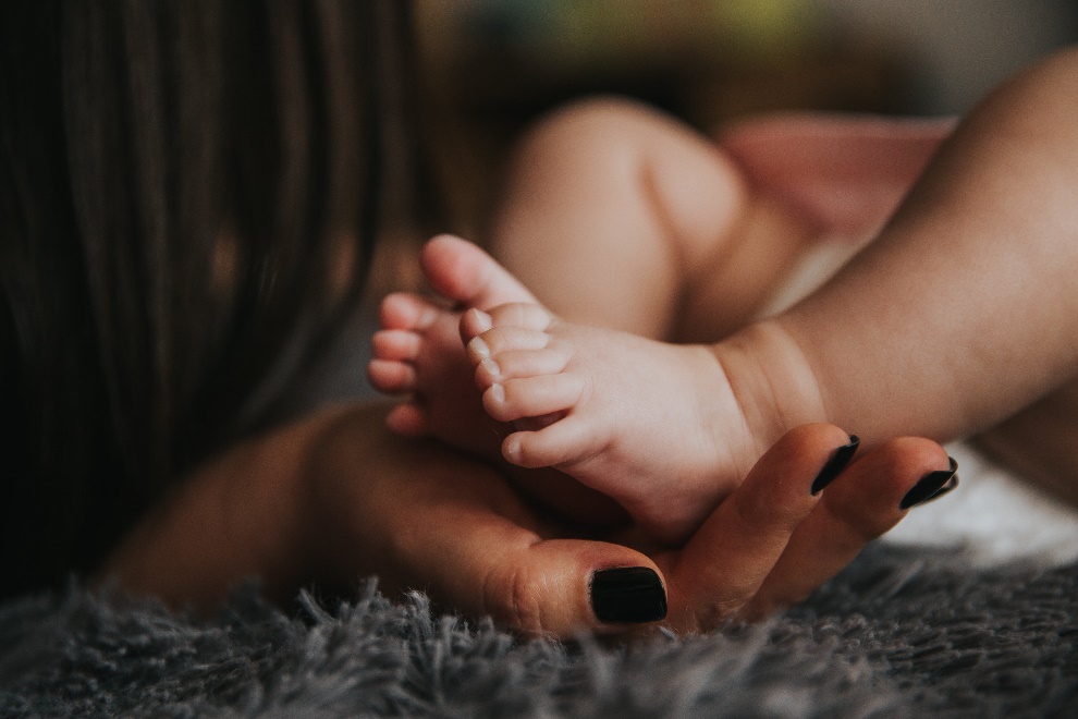Woman holding baby’s feet in her palm