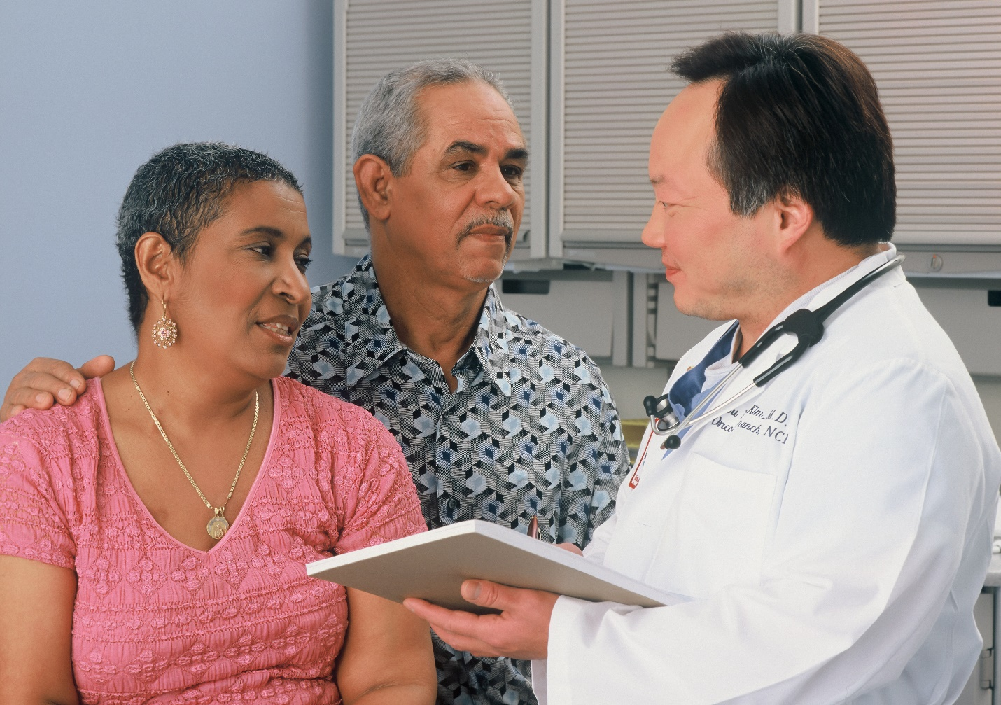 A man and woman discussing their case with a doctor