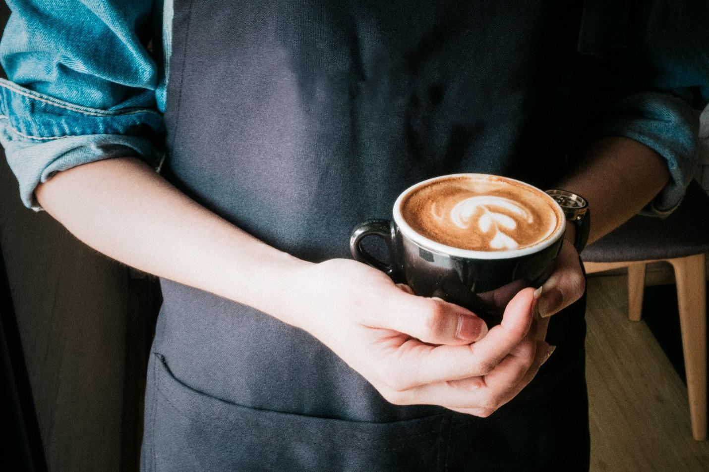 A person holding a cup of coffee in their hand