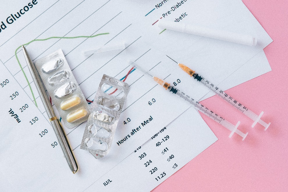 Syringes and pills lying on a lab report