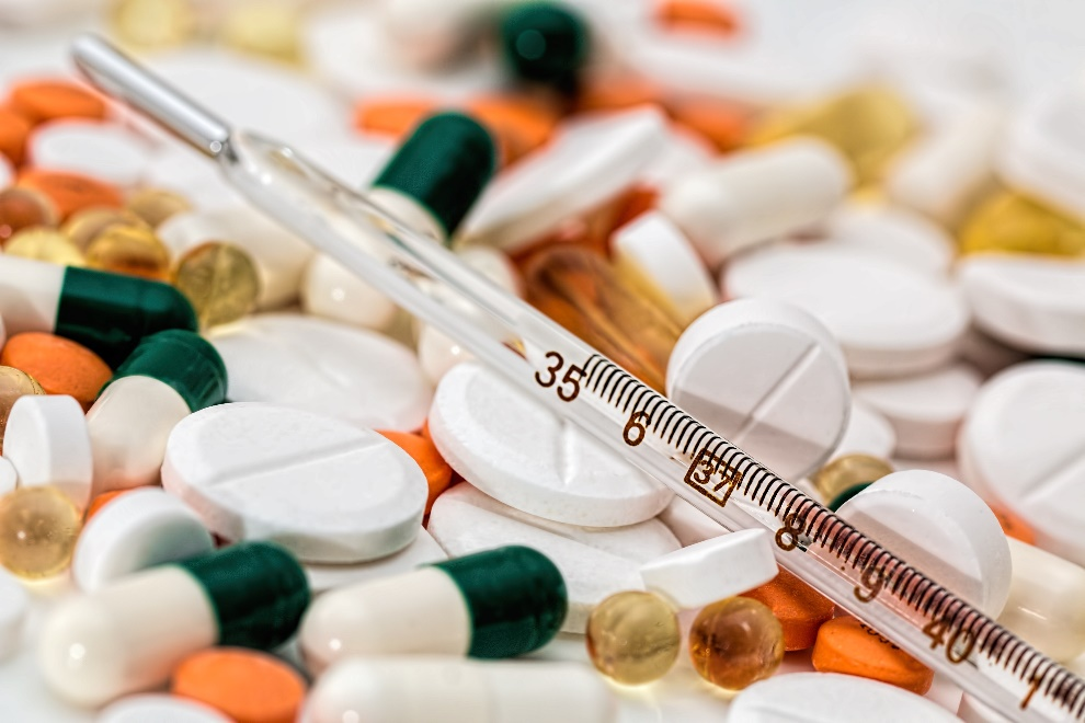 Empty syringe lying on top of pills