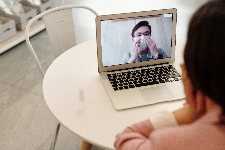 A woman speaking to a masked person over a video call