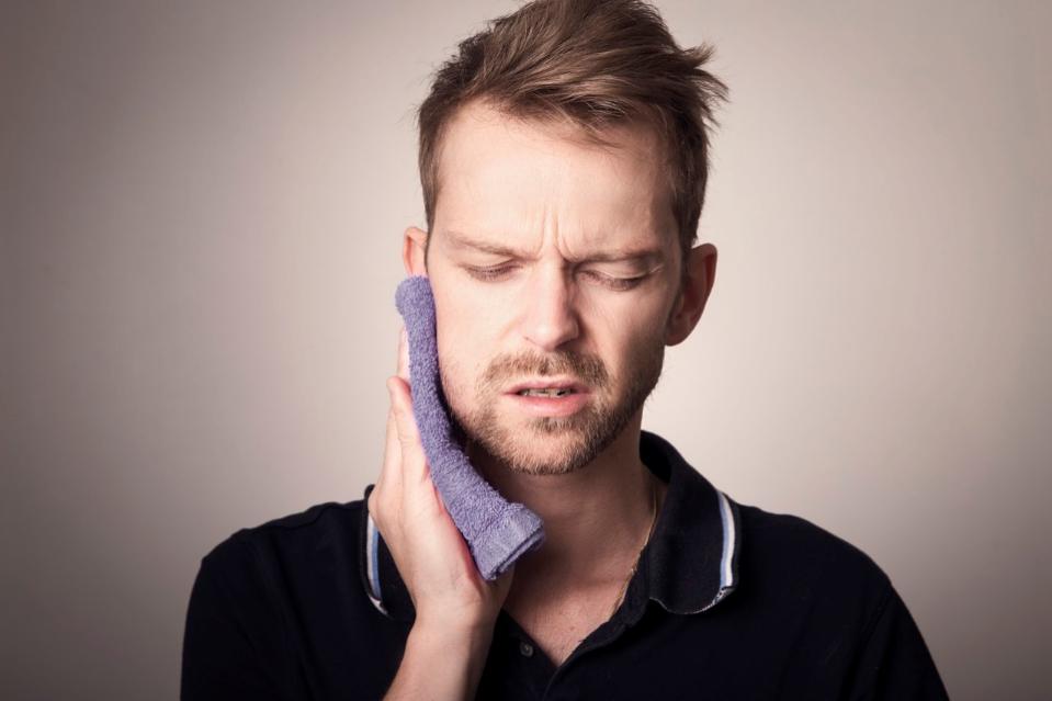 A man using a cold towel for toothache