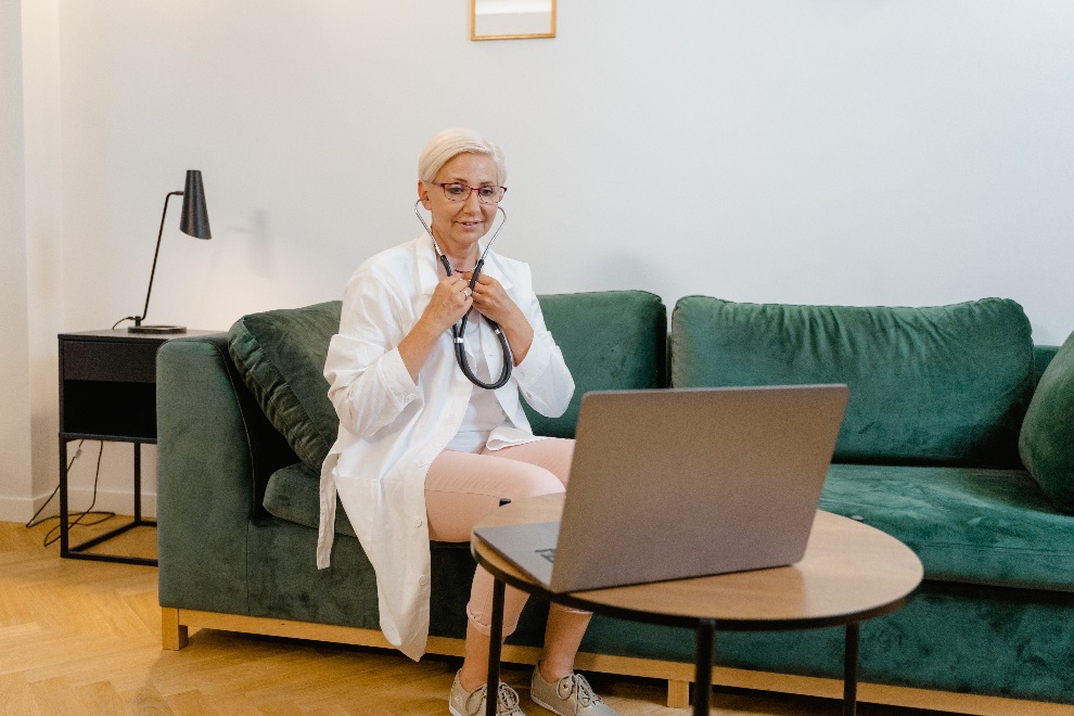 Elderly doctor sitting on a sofa for a virtual consultation