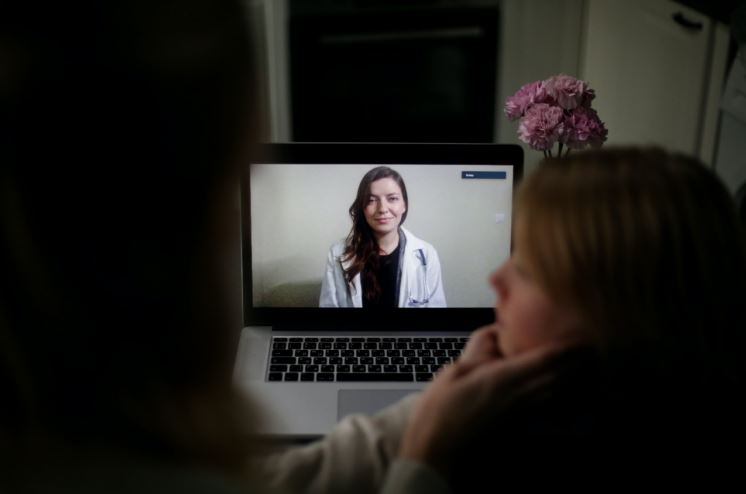 Mother and child on a virtual consultation with a doctor.