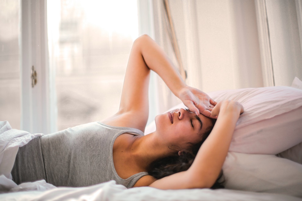 Woman experiencing migraine in bed