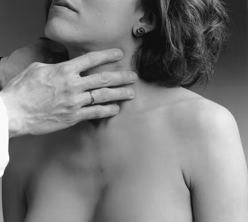 Grayscale image of a woman getting a throat checkup