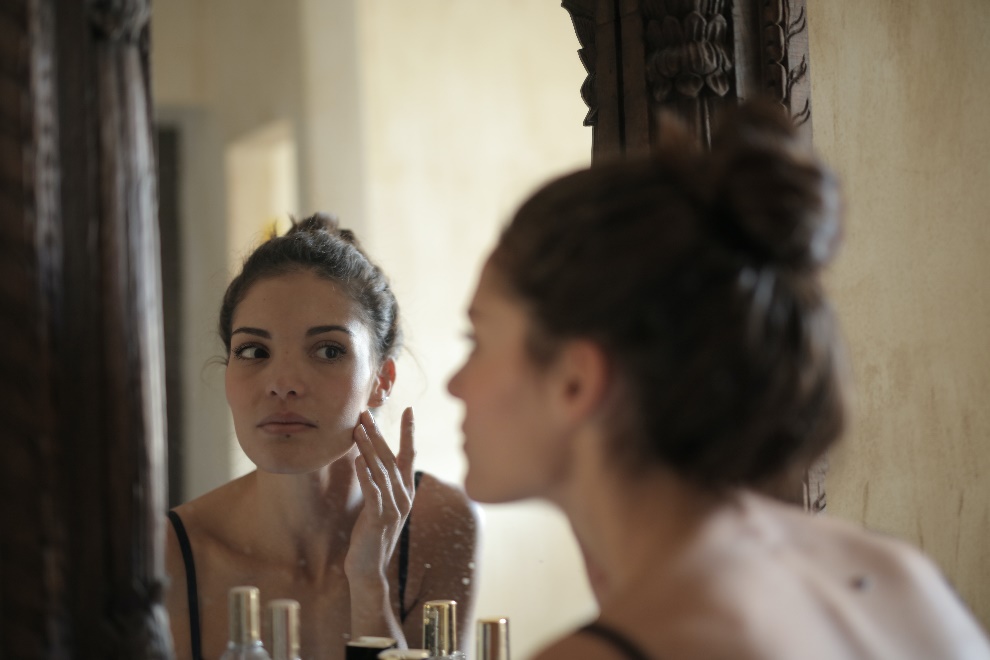 Woman inspecting her face in the mirror