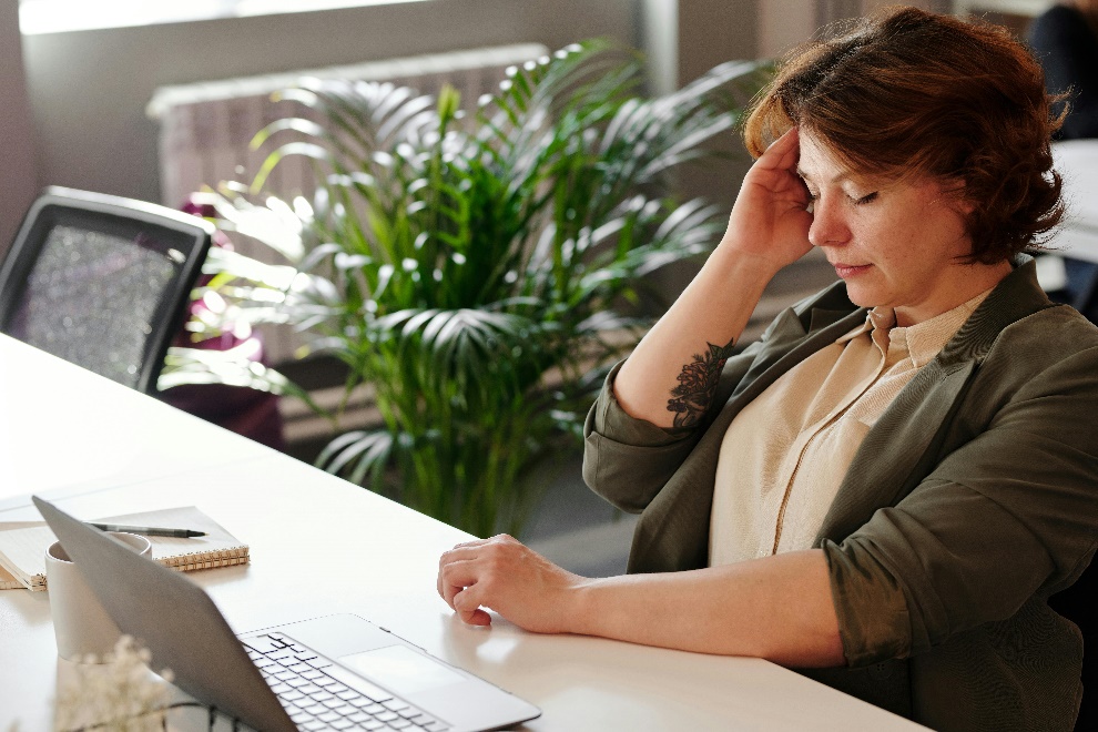 Woman experiencing headache during work