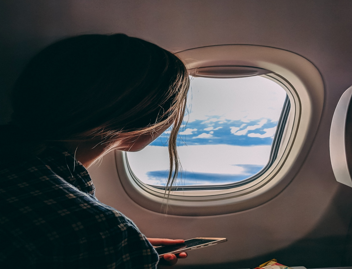 A woman looking out of the plane window.