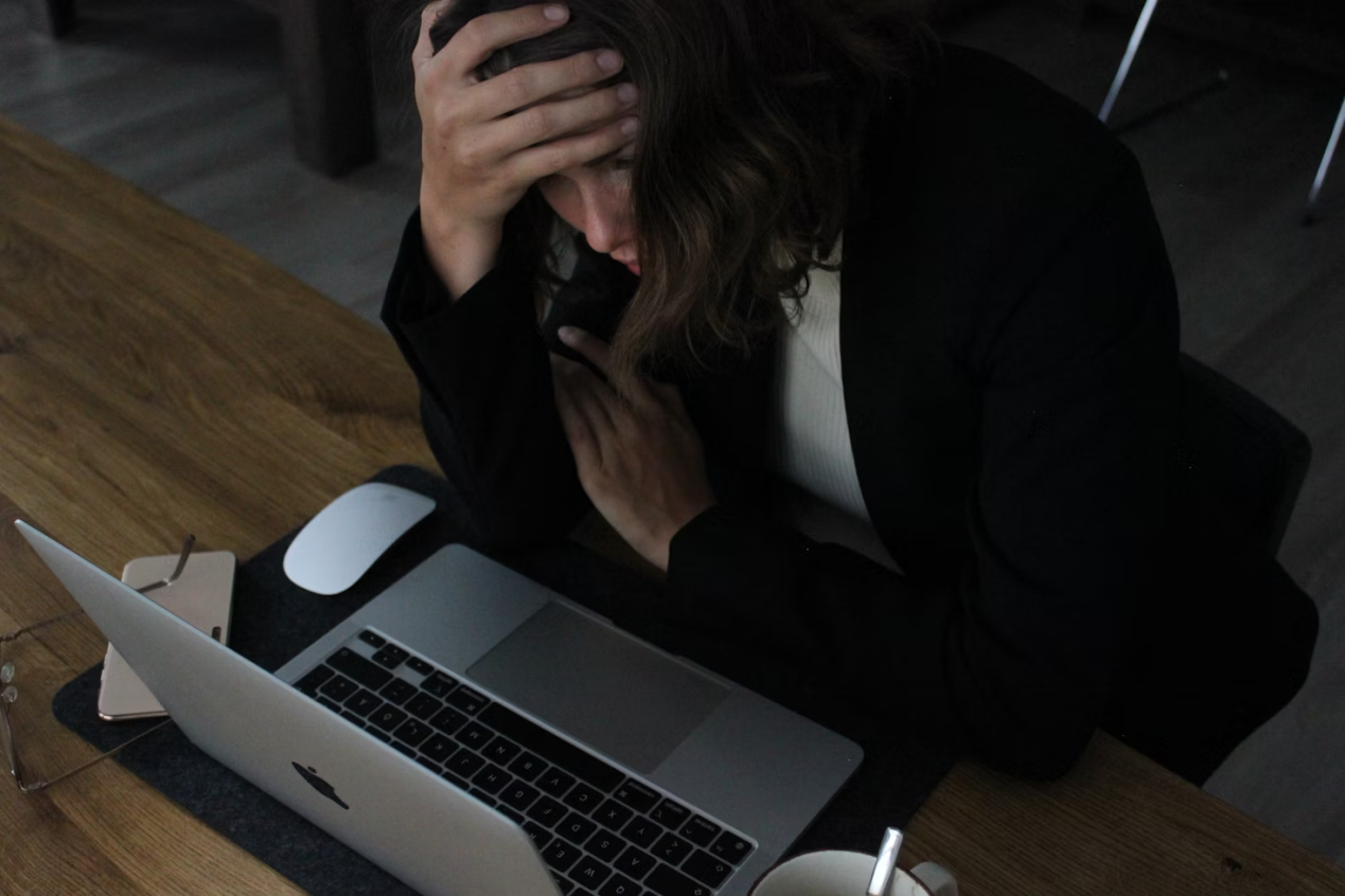 A stressed woman looking at the computer screen