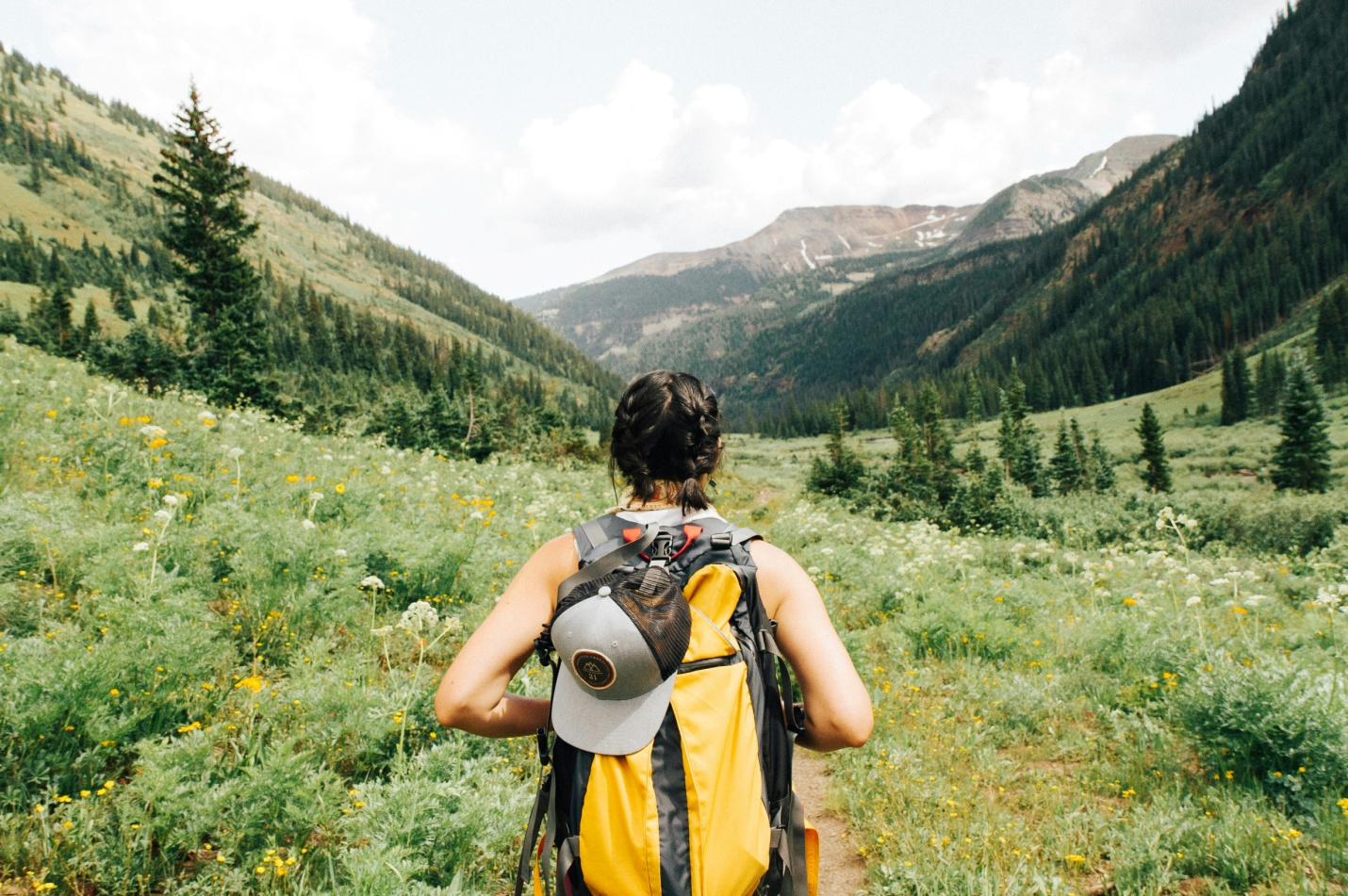 A person hiking with a yellow backpack