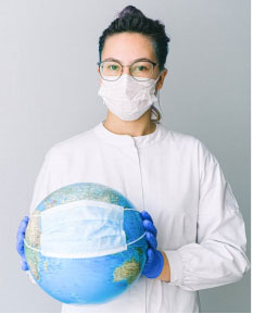 A COVID-19 doctor holding a globe with a surgical mask 