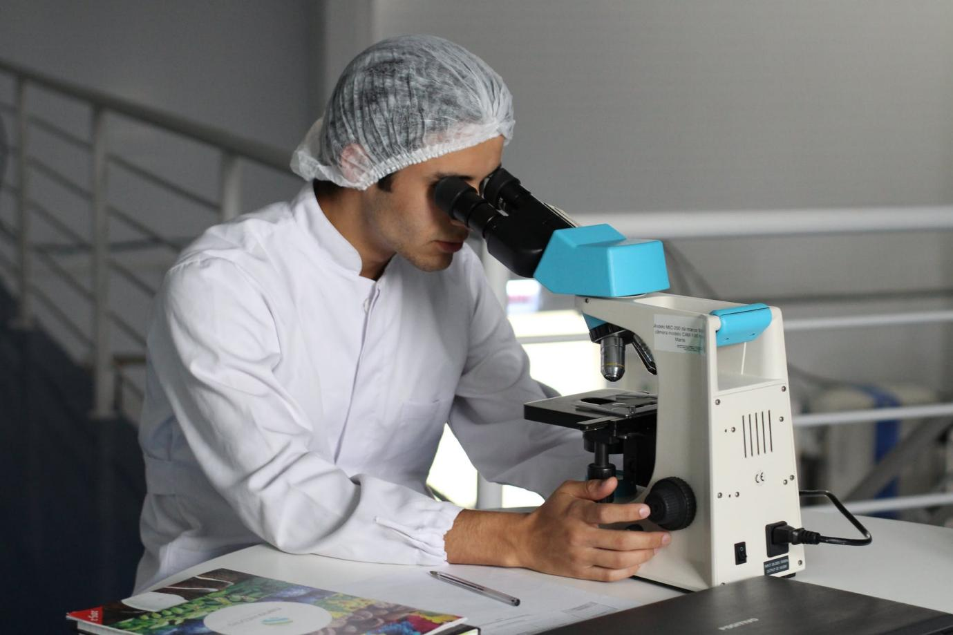 A chemist using a microscope for diagnosis