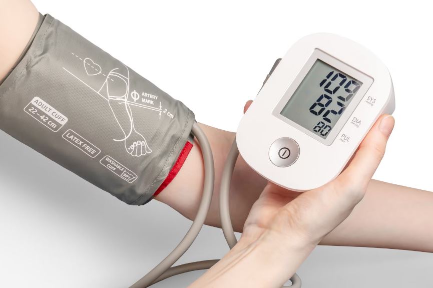 Individual using a digital blood pressure monitor to measure blood pressure