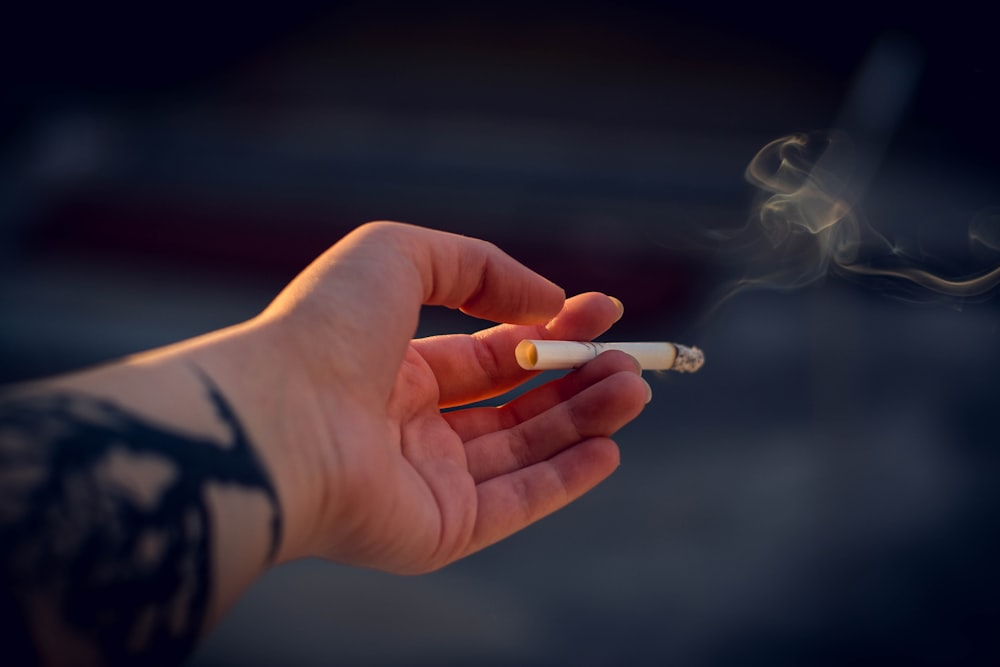 An image of a hand holding a cigarette