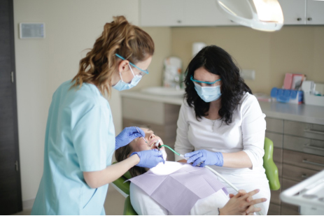 Two dentists performing a checkup on a patient