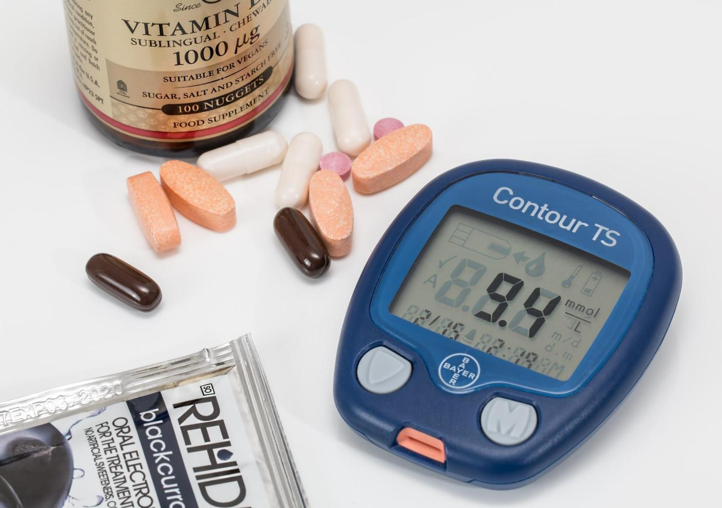 A glucometer surrounded by medication