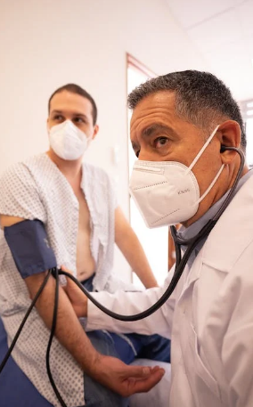A doctor checking a patient's vitals as part of erectile dysfunction treatment  