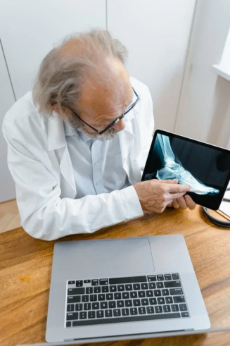 An old doctor showing a foot X-ray to a colleague online