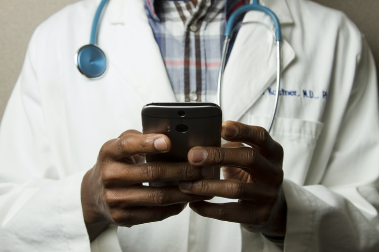 A doctor using his phone for online appointments