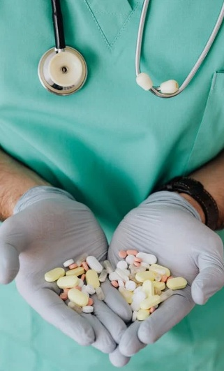A physician holding pills in both hands