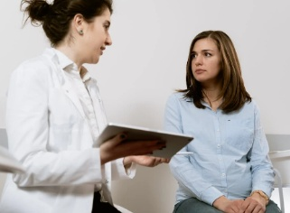 A pregnant woman discussing symptoms of gonorrhea with her doctor at a clinic