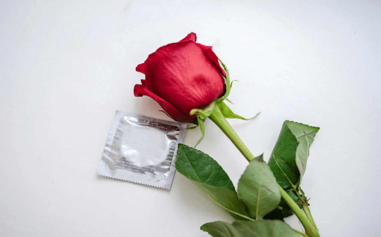 A rose next to a condom symbolising safe sex.