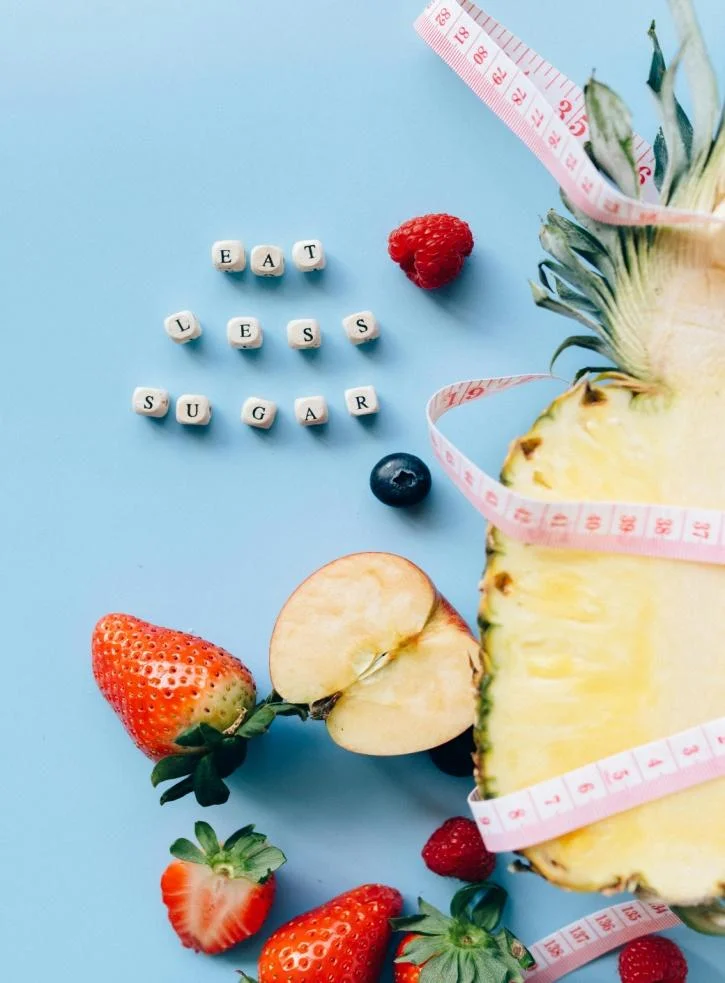 A sliced apple, a pineapple, strawberries and raspberries