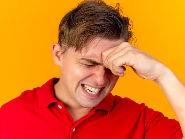 Boy scratching his itchy eye due to pink eye.