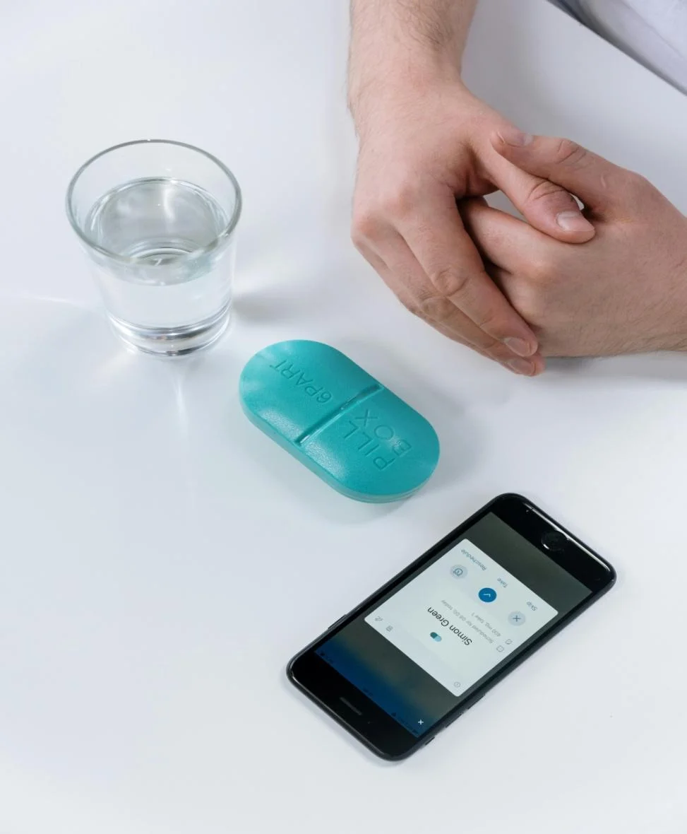 Pill, a glass of water, and a mobile phone